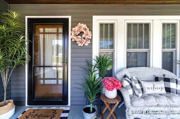 Full-view storm door over an entry door beside double-hung windows