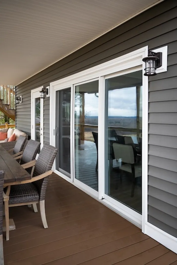 White three-lite sliding glass door on a back porch