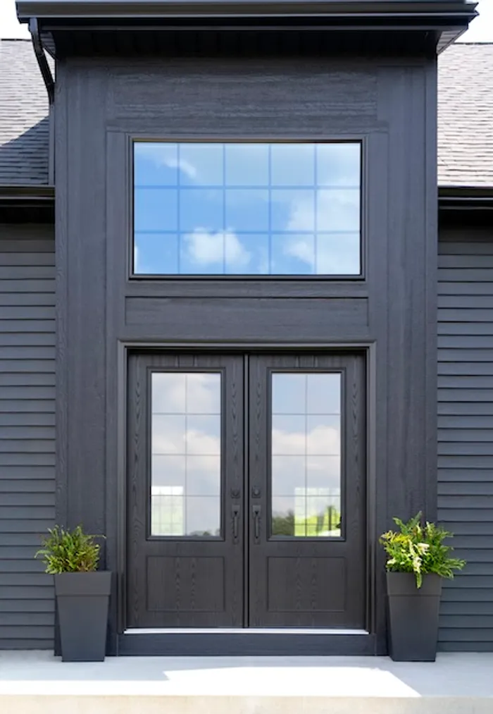 Coal black entry doors with a glass transom and internal grids