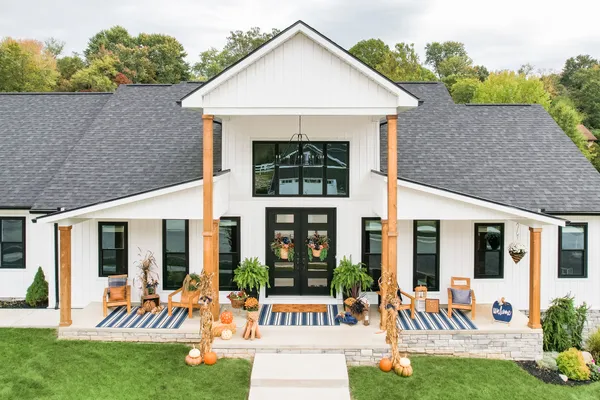 Black double entry doors on a white farmhouse porch