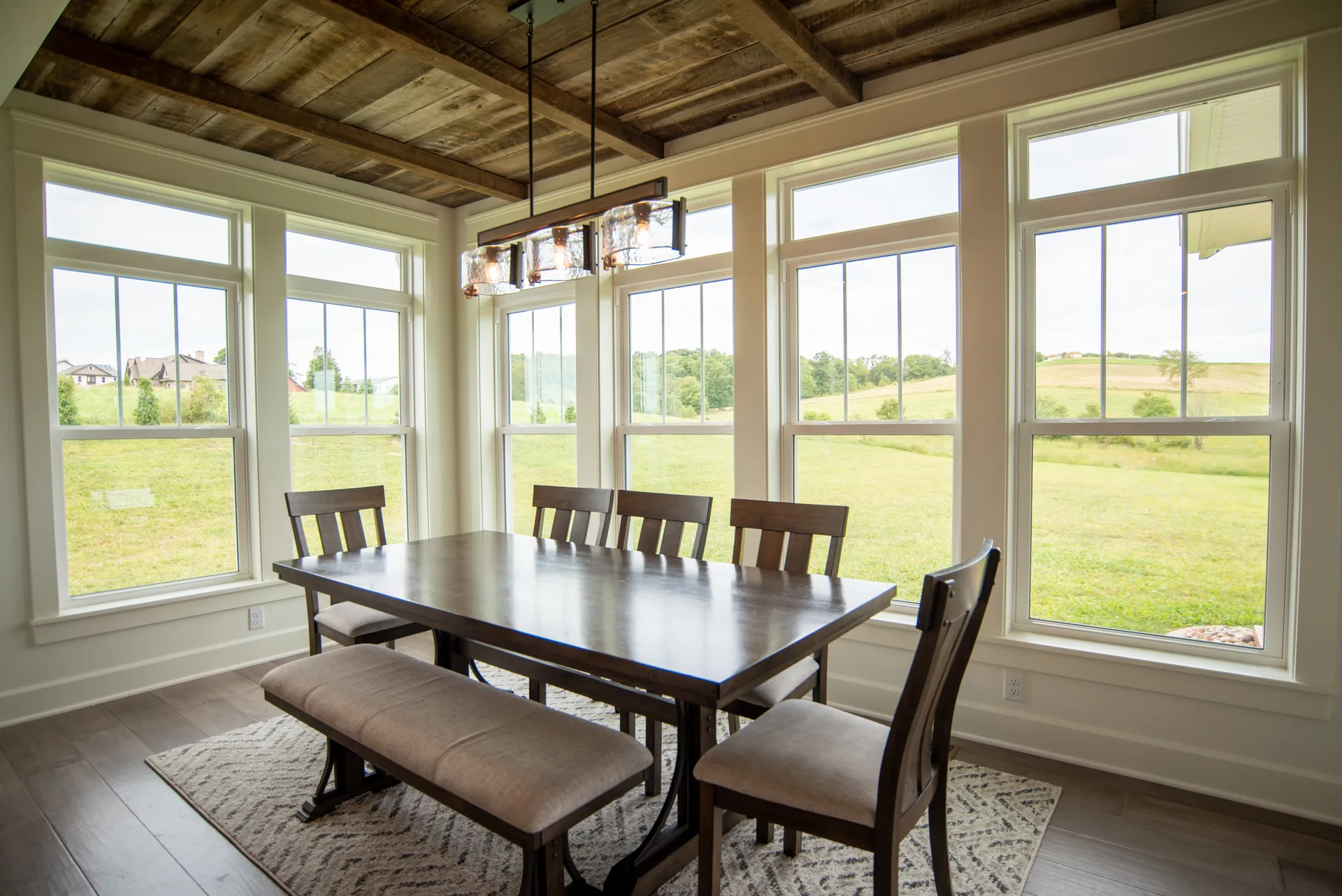 Bright dining room with a wide window looking out onto the backyard